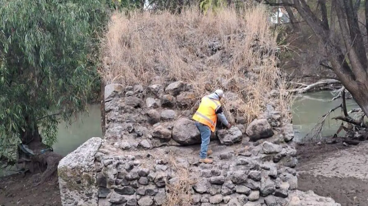 Realizan trabajos de limpieza y mantenimiento del arco del antiguo puente de piedra