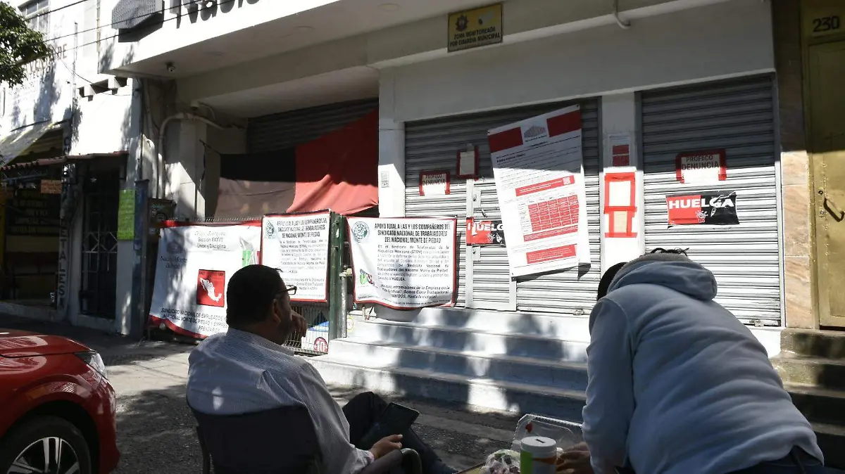 Pese al frío, los trabajadores en huelga de Nacional Monte de Piedad continúan con la bandera rojo negra en alto