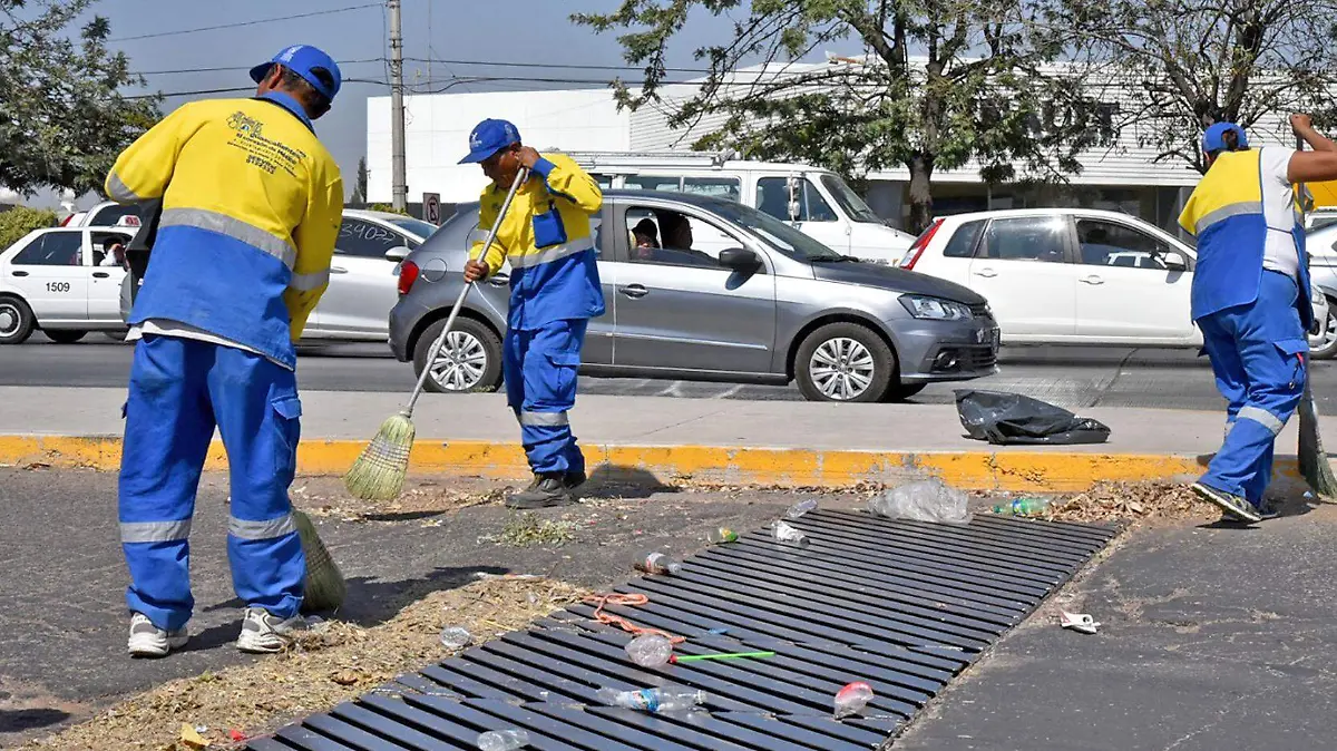 trabajadores limpian coladera