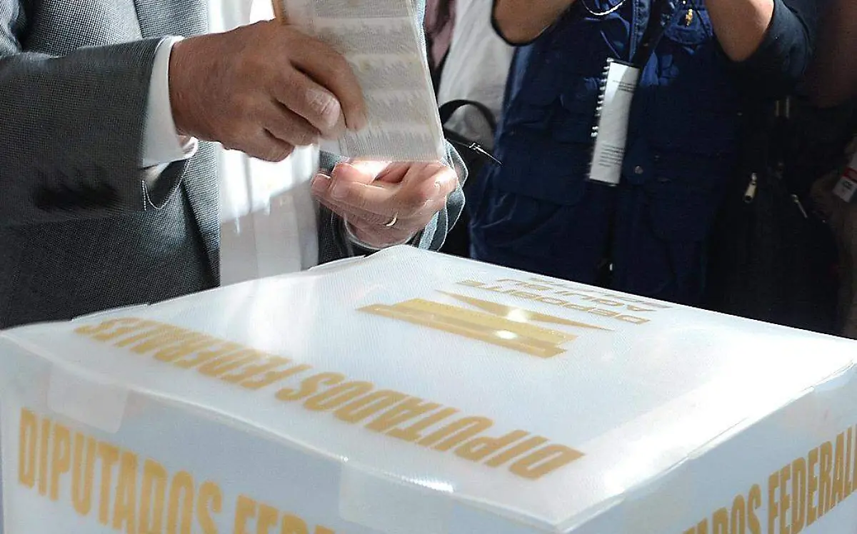Persona insertando su voto en la urna