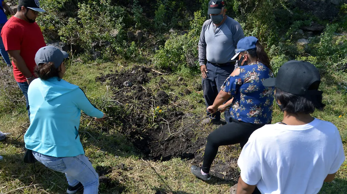 Buscan lugares con tierra removida donde podria haber mas restos