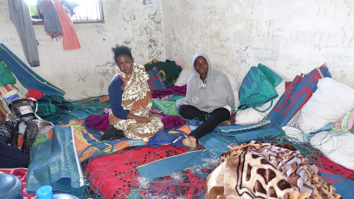 07 EXTRA Two female migrants sit in a dirty room  covered in blankets mixed with fishing line, water jugs, flags, et with writing on the wall January 24, 2017 Photo by_ Tankred Stoebe_MSF