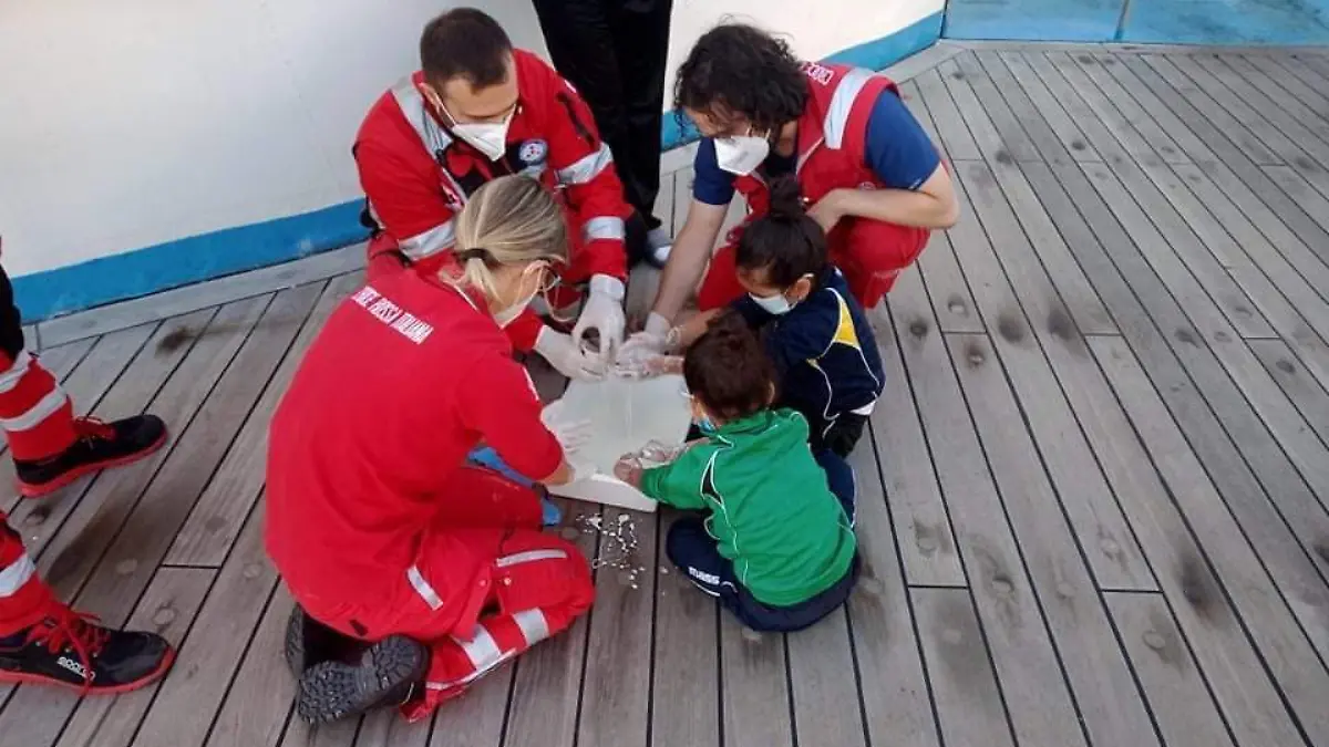Red Cross workers with small children with sudsy pan