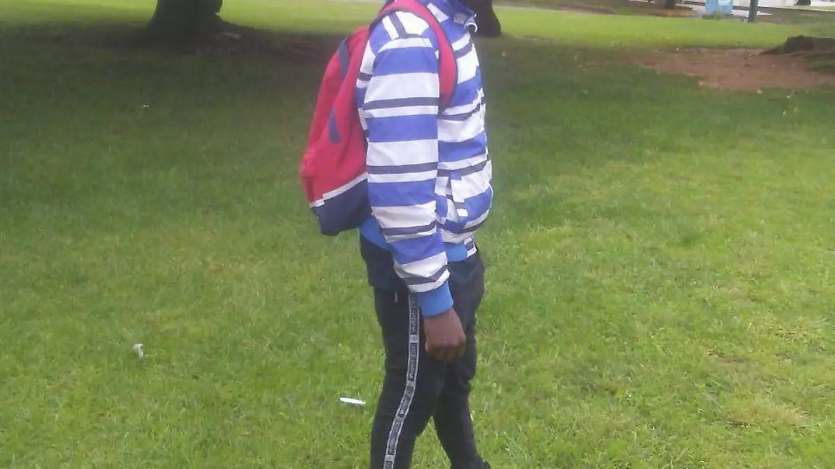 Aliou Candé, standing in park with backpack, via Jacaria Candé