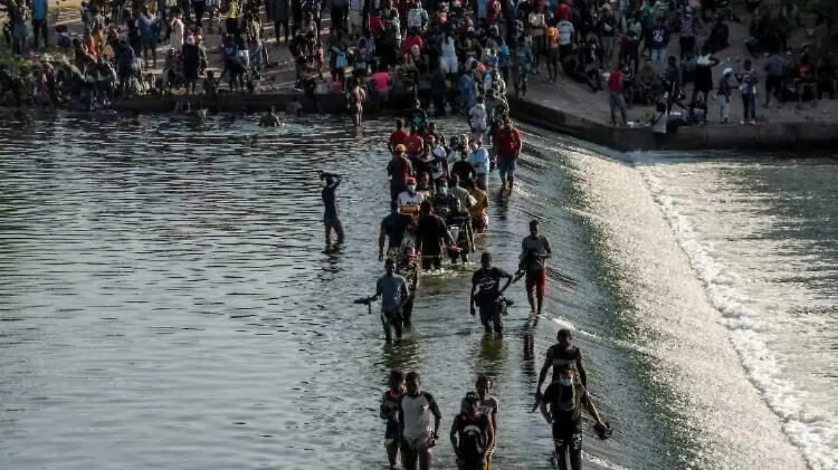 Miles de migrantes haitianos estan  en un puente fronterizo