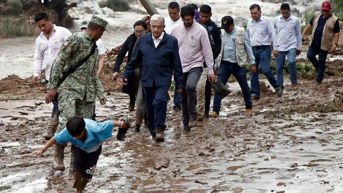AMLO caminando entre el lodo por deslave en la Autopista del Sol