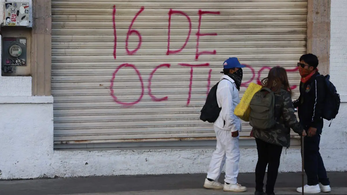 Normalistas frente a una pinta en negocio