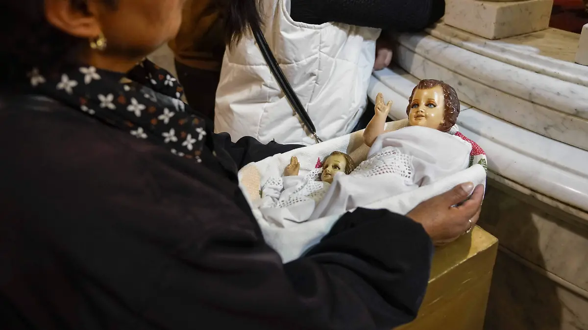 Mujer y una figura de Niño Jesús