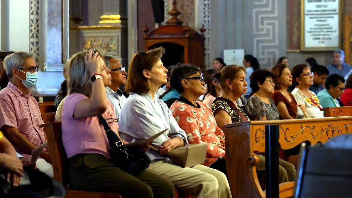 Personas escuchan misa