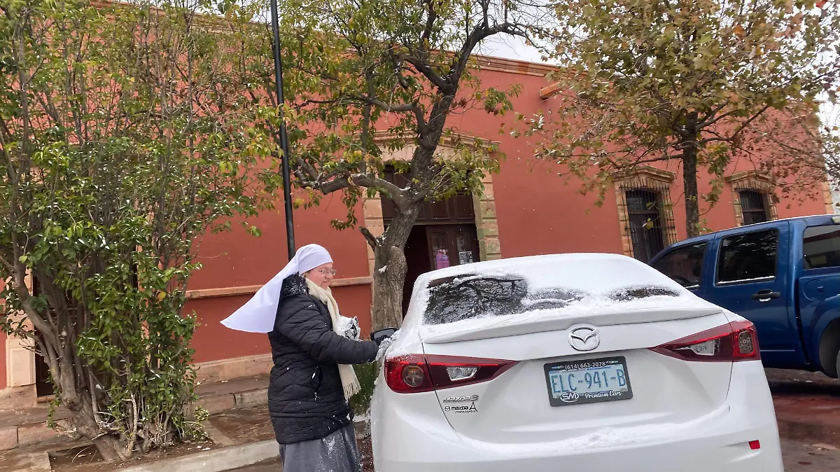 Monja jugando con la nieve