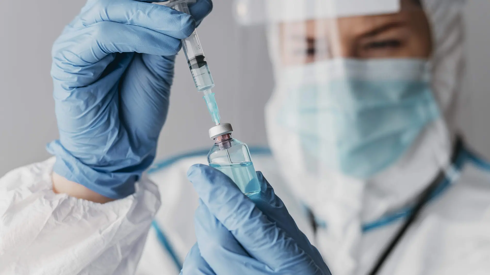 doctor-holding-preparing-vaccine-while-wearing-protective-equipment