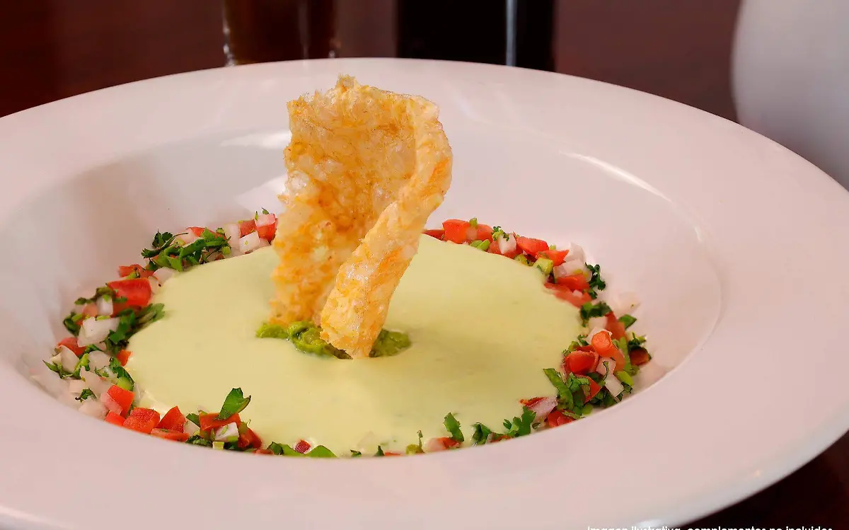 Una creación con el nombre de 'crostini de puerco', el cual se encuentra coronado con un trozo de chicharrón