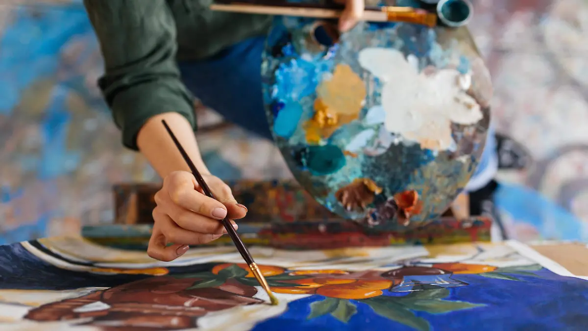 vista-superior-atractivas-manos-mujer-dibujando-imagen-increible-sobre-lienzo-moderno-acogedor-taller-arte
