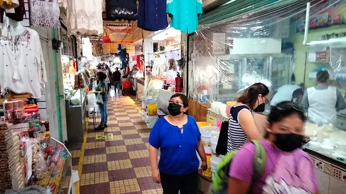 Personas en mercado y con cubrebocas