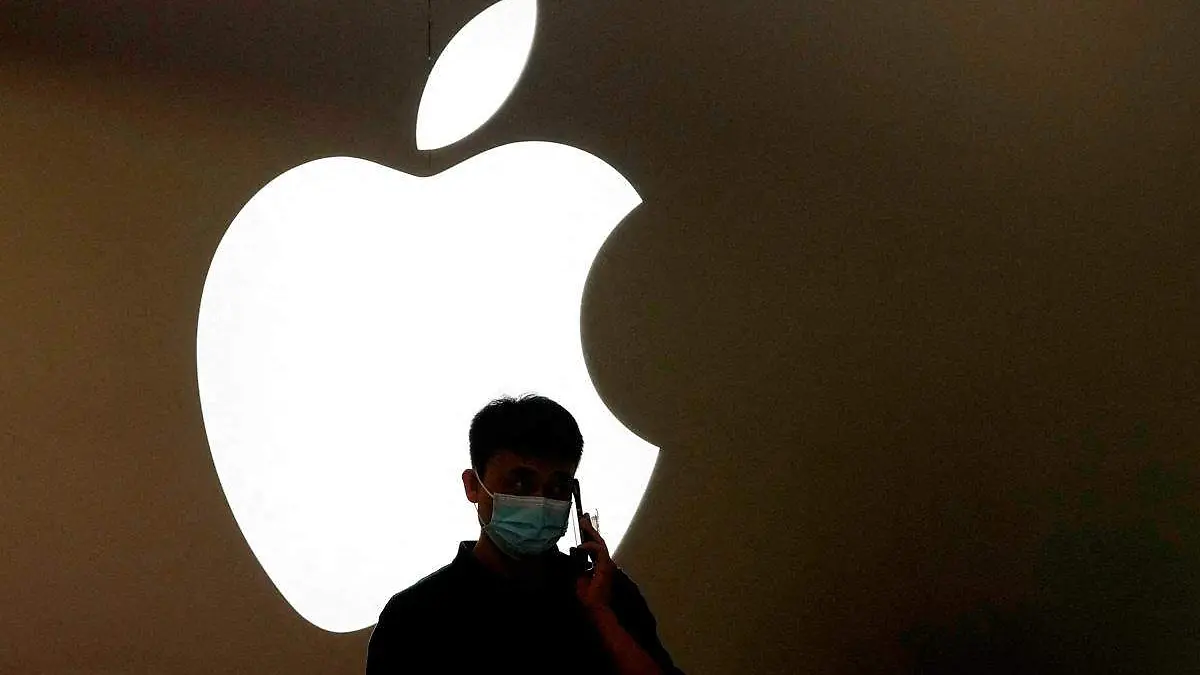 Apple logo de la empresa y frente a él la sombra de una persona