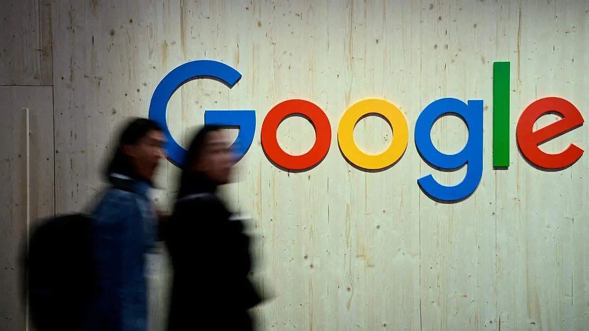 Google, mujeres pasan frente a uno de los logos de la empresa