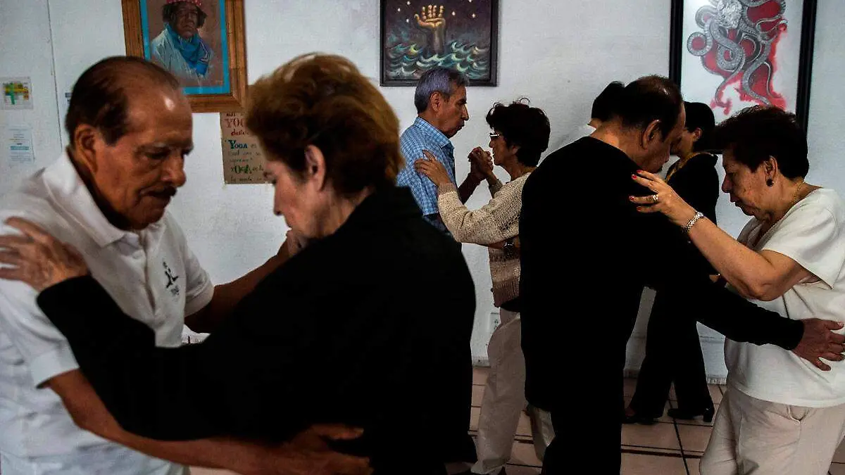 adultos mayores en una clase de tango bailando