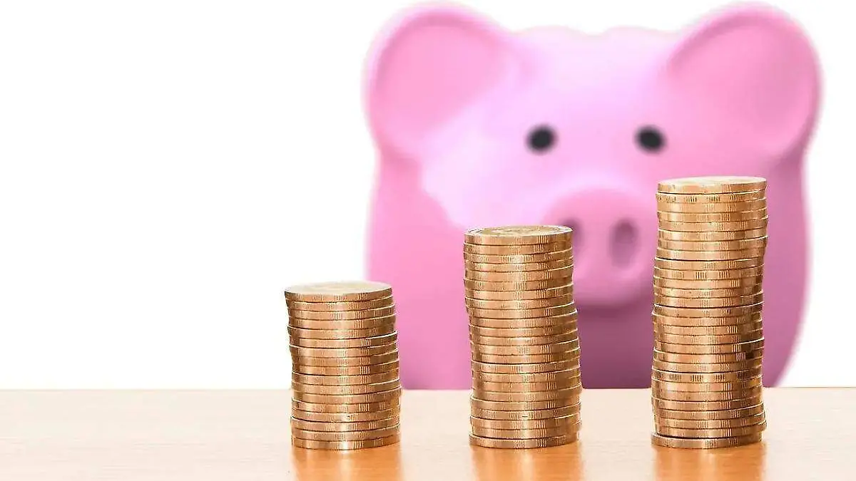 alcancia de cerdito y unas monedas