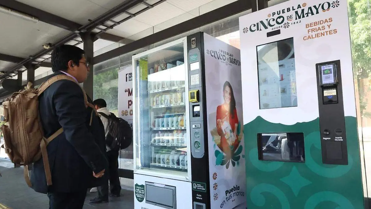 persona en estacion del RUTA Puebla frente a maquina expendedora