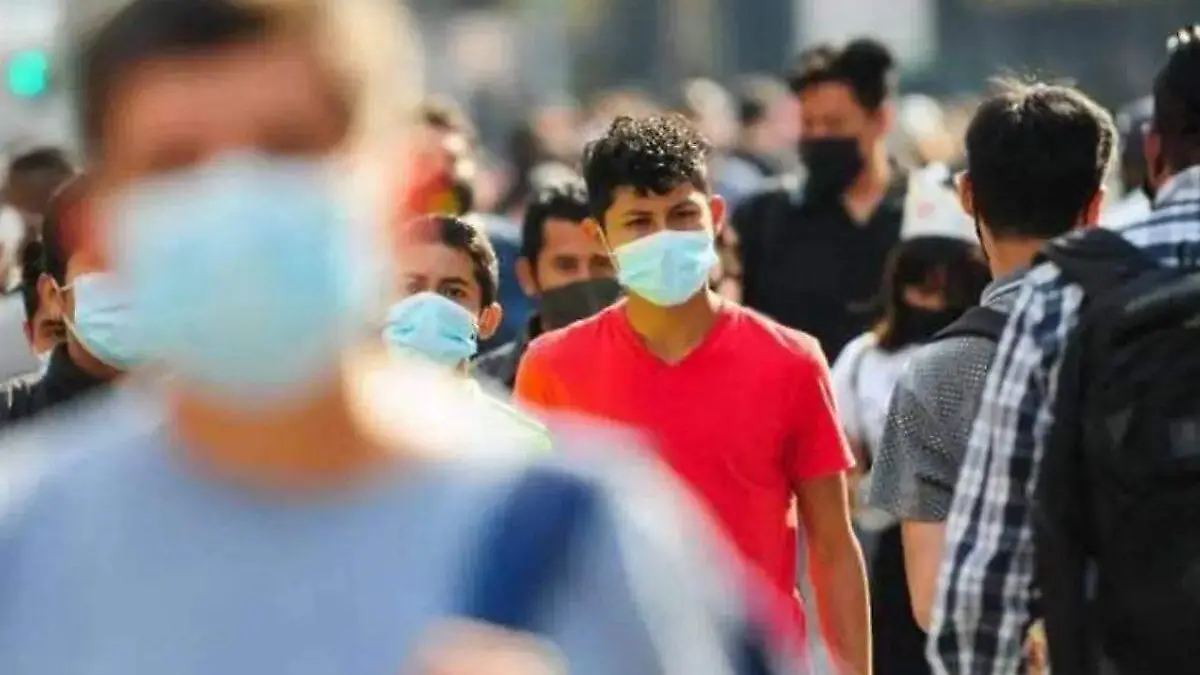 personas caminando por la calle con cubrebocas