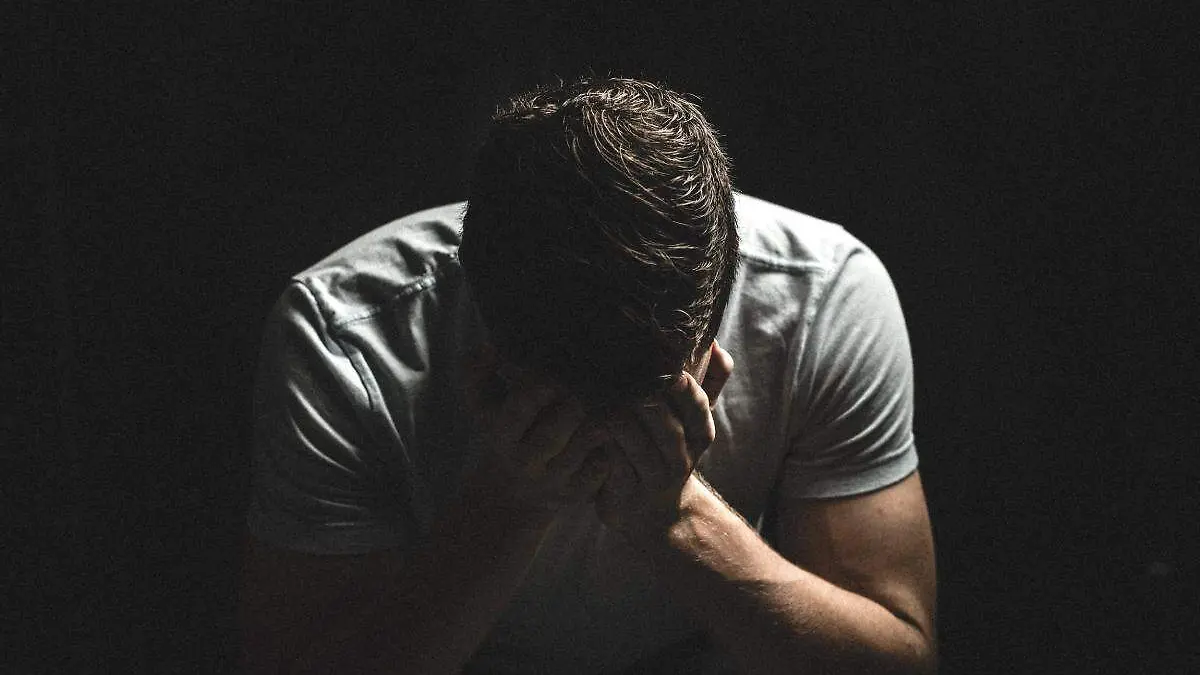 hombre cubriendose el rostro con las manos