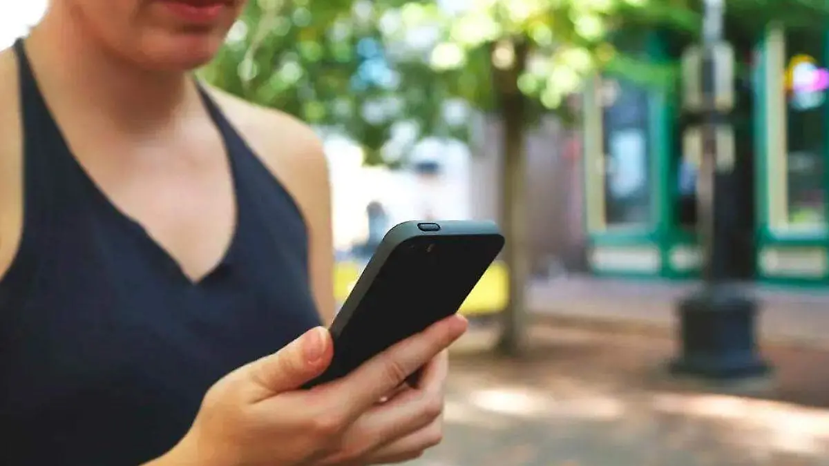 mujer utilizando su celular en la calle
