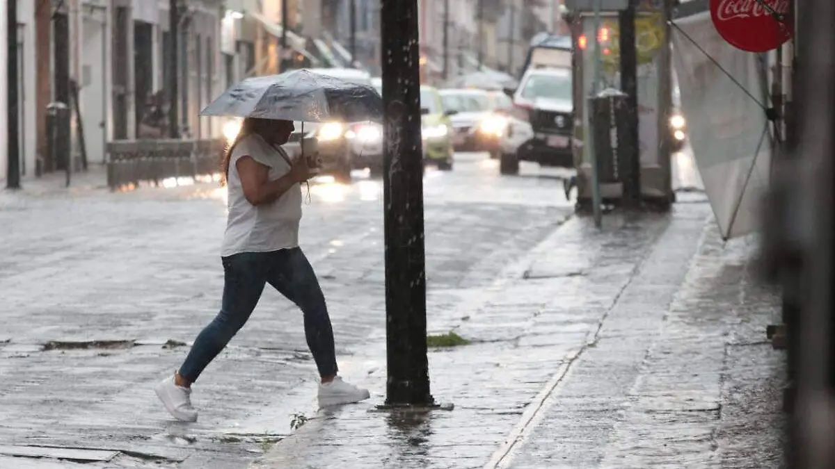 Lluvia sobre Puebla, persona camina con su paraguas en medio de la lluvia