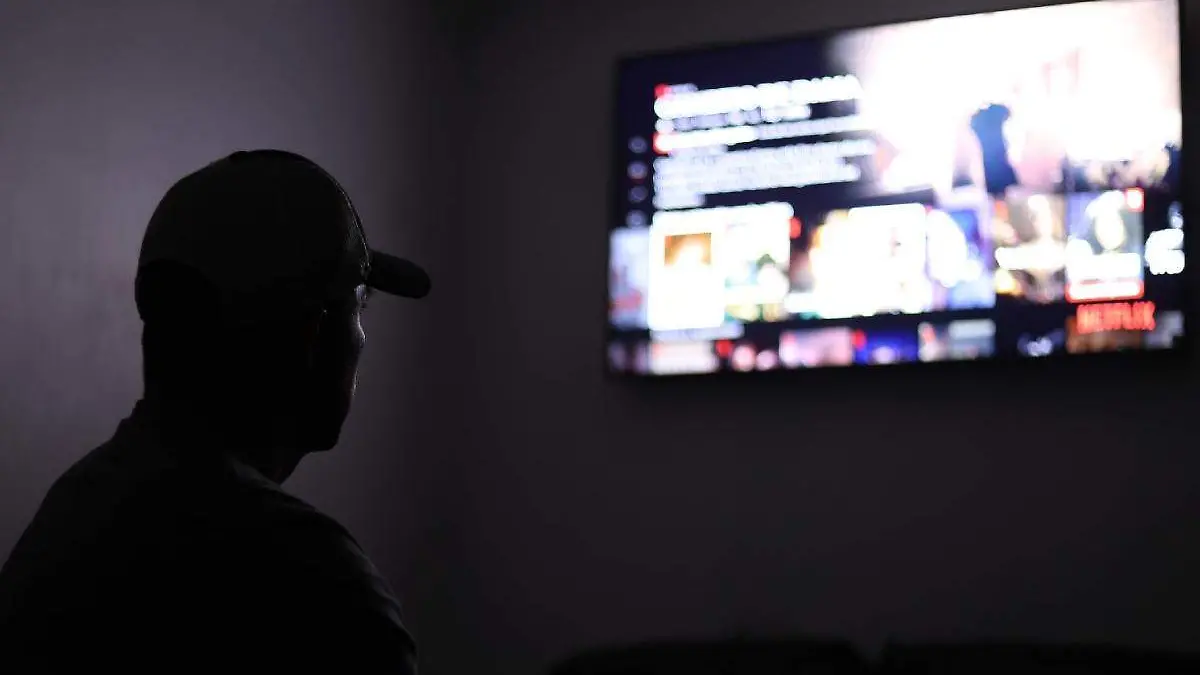 persona viendo television por la noche