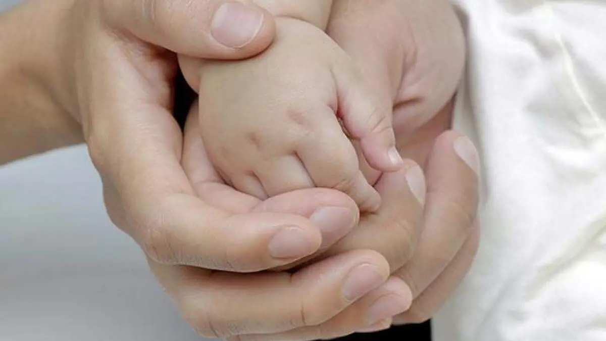 mano de bebe tomada por sus padres