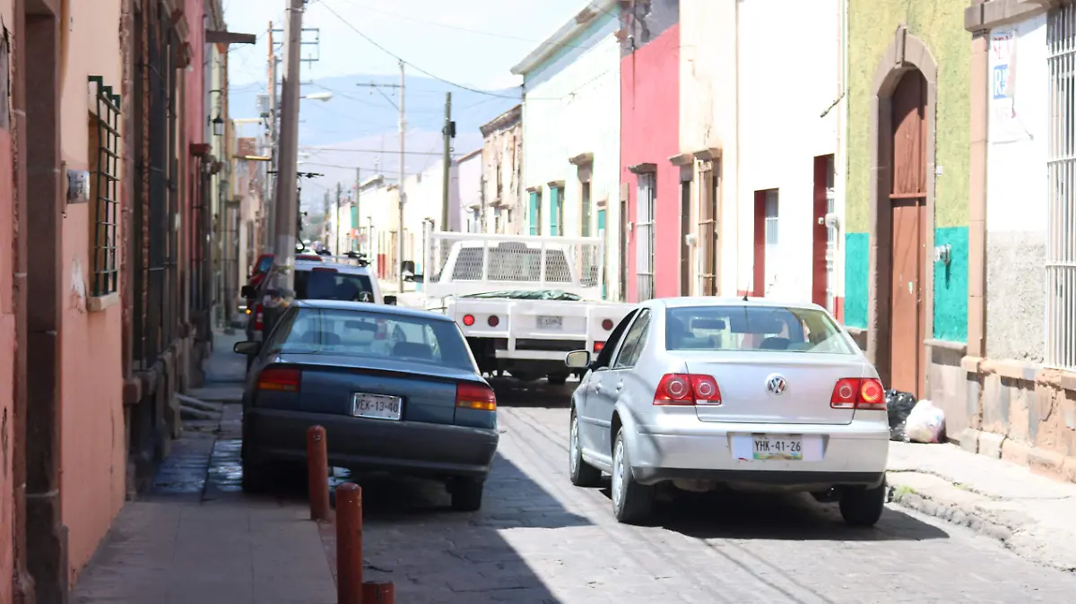 Carros estacionados en banqueta en Independencia