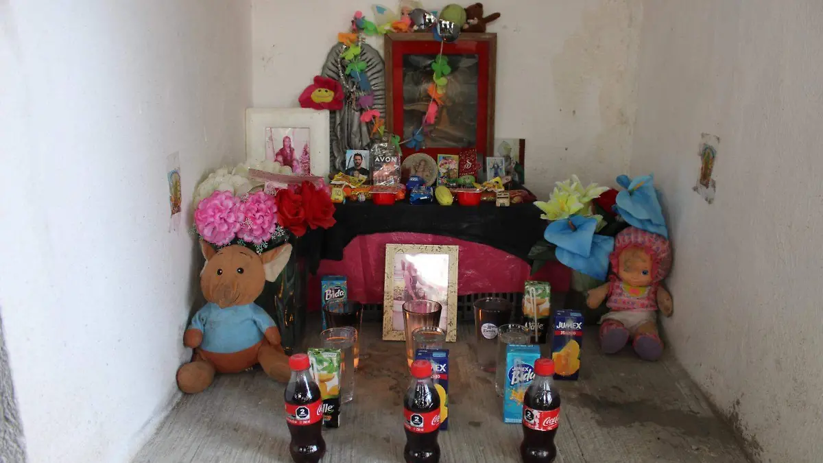 Instalaron un altar debajo de la escalera de concreto que conduce al departamento