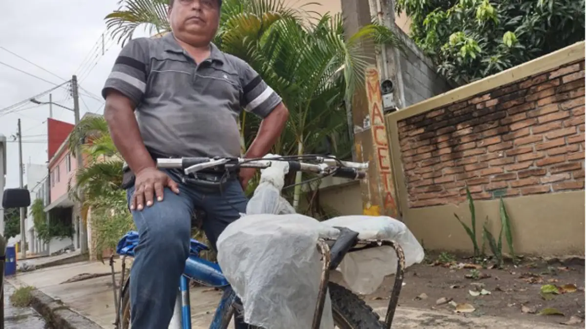 Con su bicicleta lleva los periódicos a las casas de sus clientes : Juan Hernández