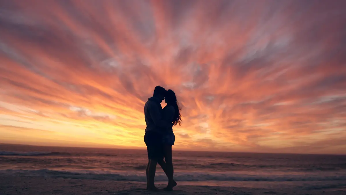 happy-couple-kissing-on-beach-at-sunset-silhouette-in-love-dating-on-honeymoon-red-dragon_4kszdpz8__F0000