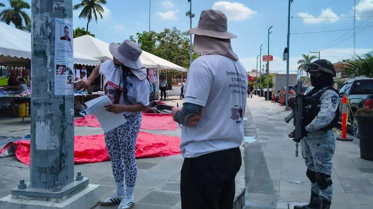 Custodiados por elementos de la Guardia Nacional, los padres de familia realizan su labor de colocar los anuncios de sus hijos