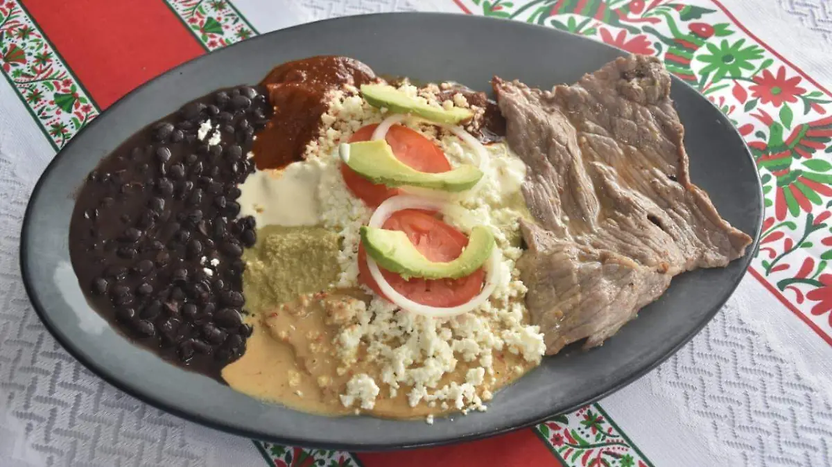 Encremadas, enmoladas y enchiladas acompañadas de frijoles negros y cecina