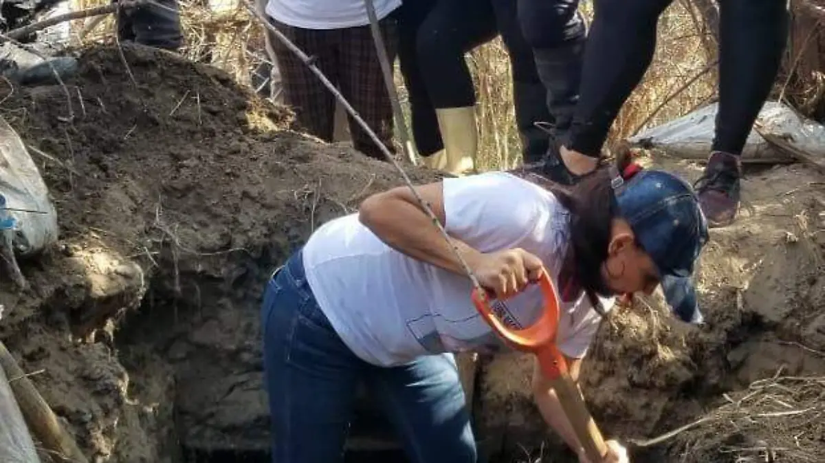 Examinando fosa clandestina