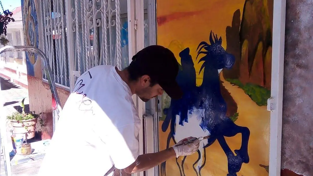 ARTISTA PLÁSTICO PINTA PUERTA