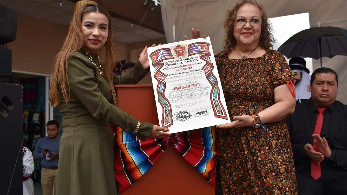 La directora de Las Manos del Mundo, María del Socorro Oropeza, y la presidenta municipal de Contla firman el hermanamiento