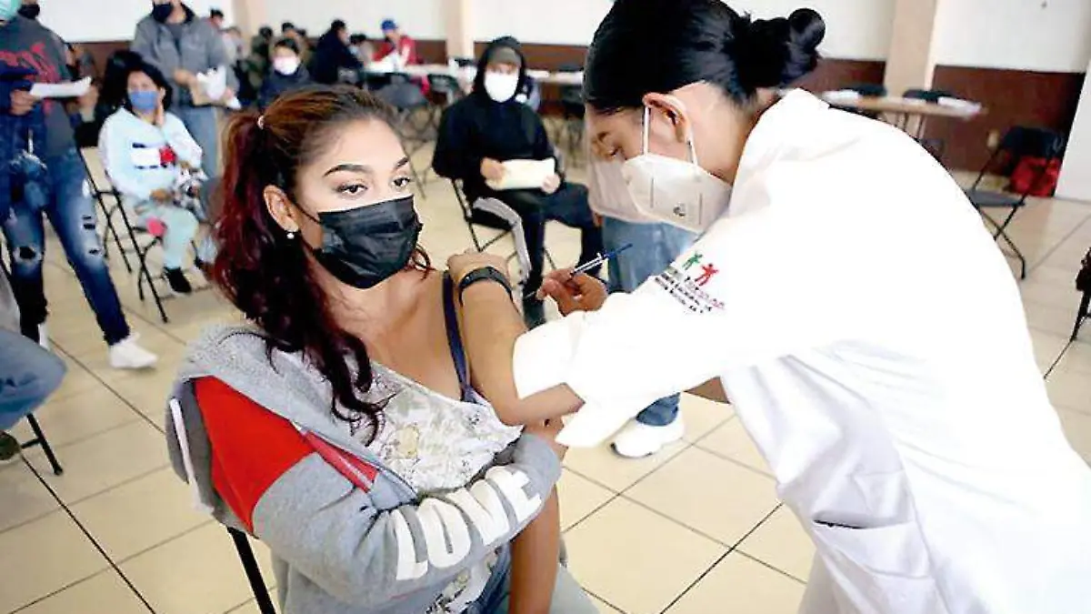 Una joven recibe la aplicación de la vacuna contra Covid-19