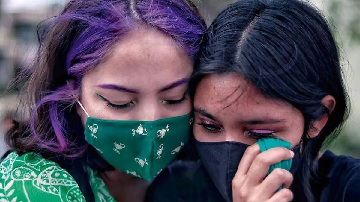 Dos participantes en marcha feminista en una muestra de solidaridad