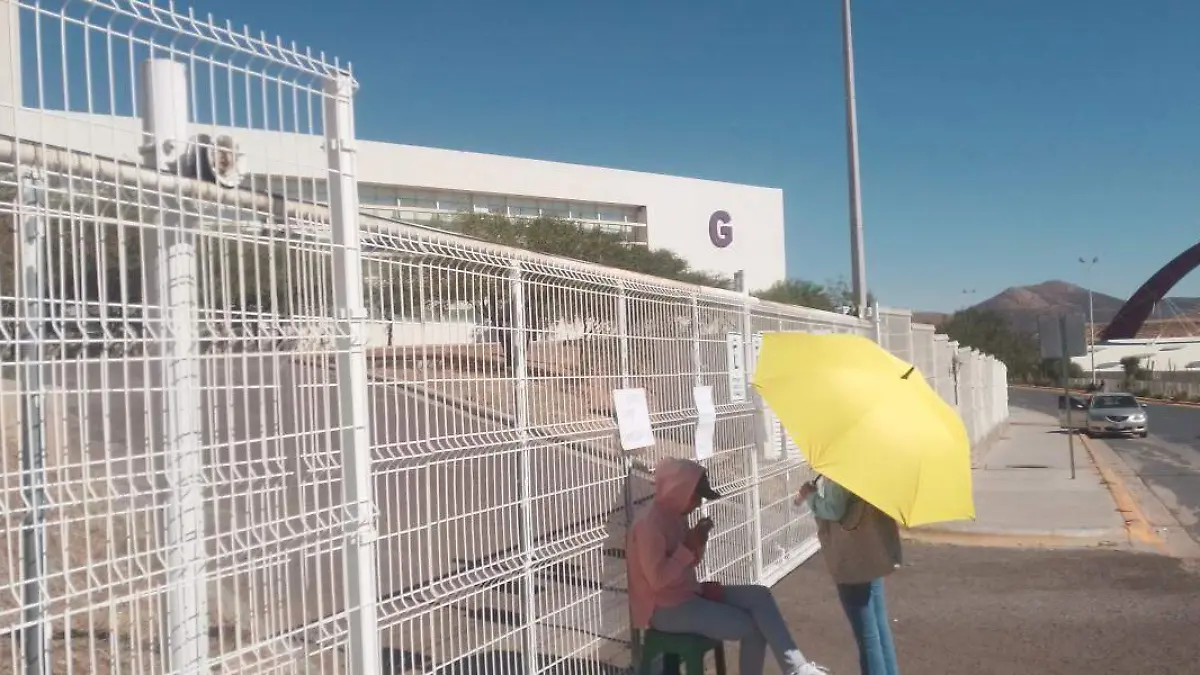 Maestras cuidando puerta de ciudad administrativa