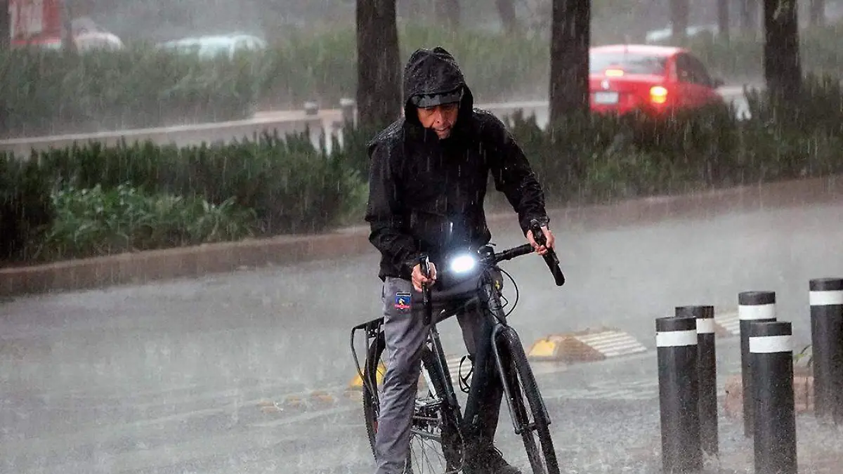 persona con impermeable bajo la lluvia