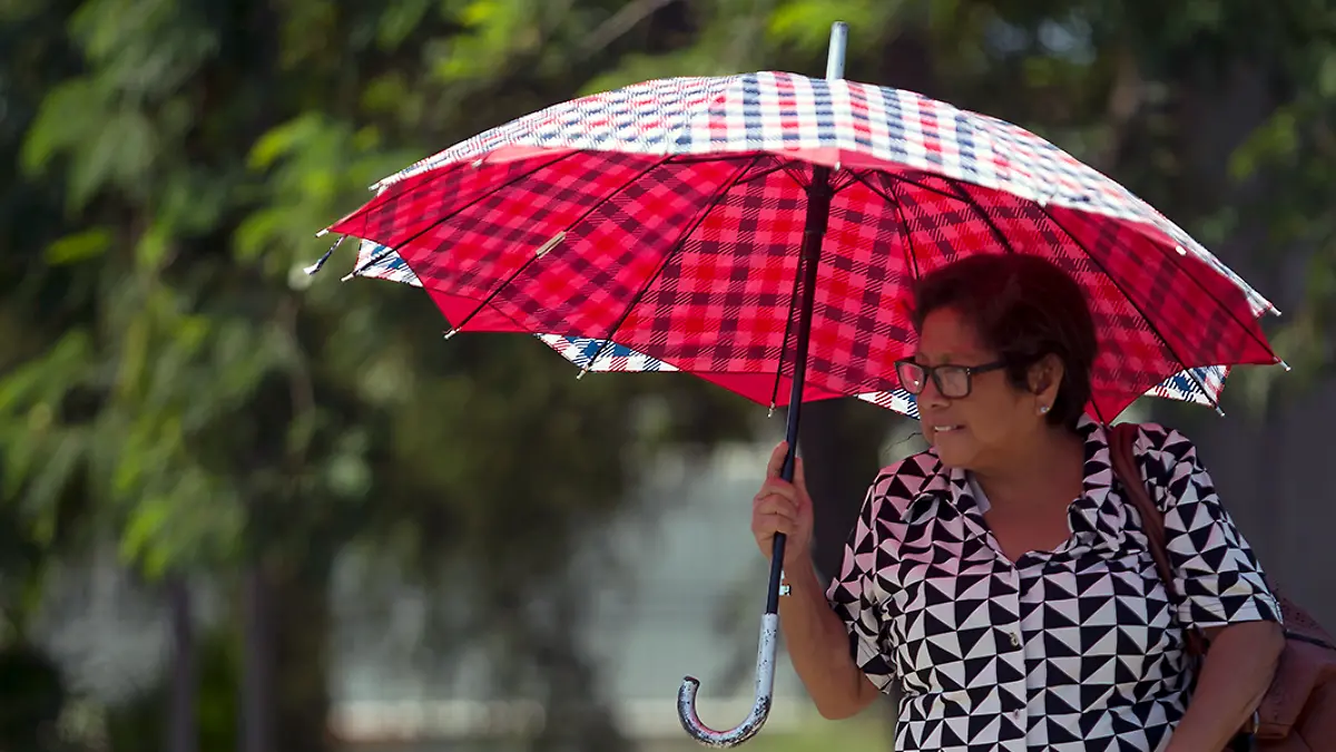 Mujer usa sombrilla para evitar los rayos solares