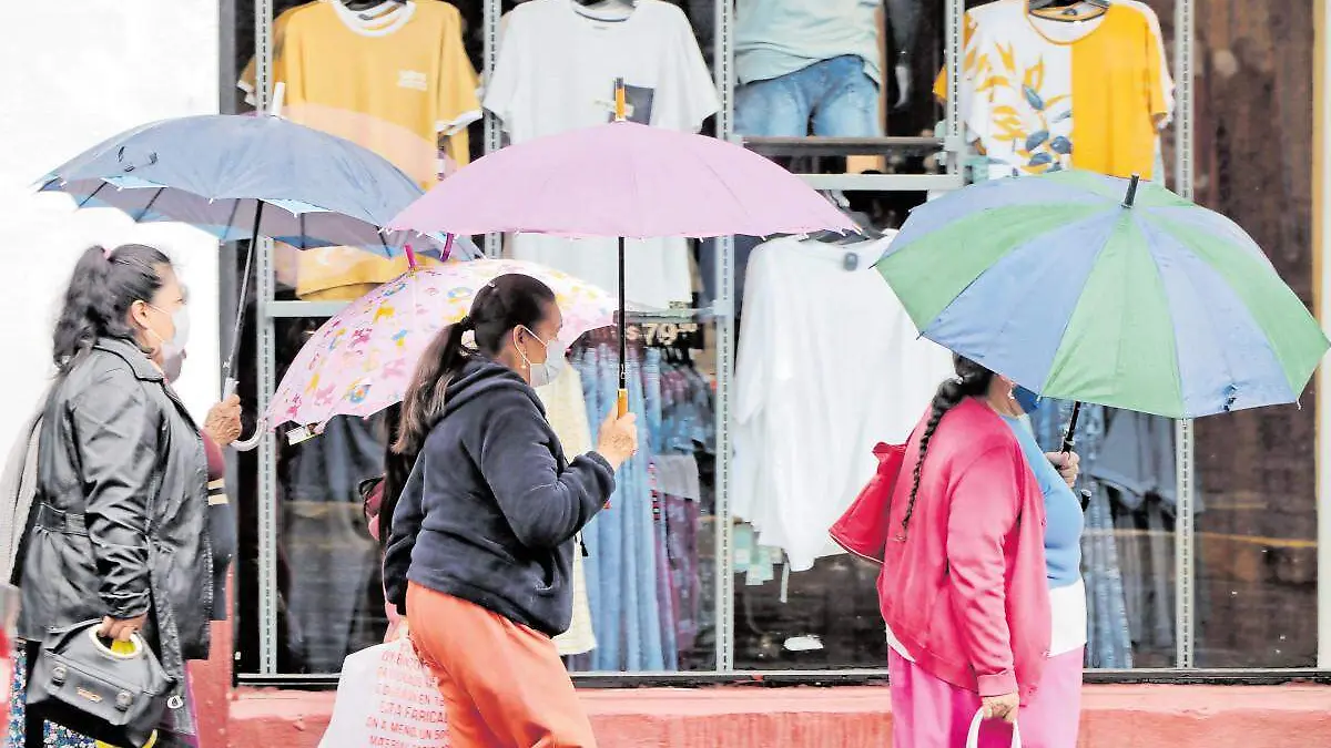 Mujeres portando sombrilla en día lluvioso