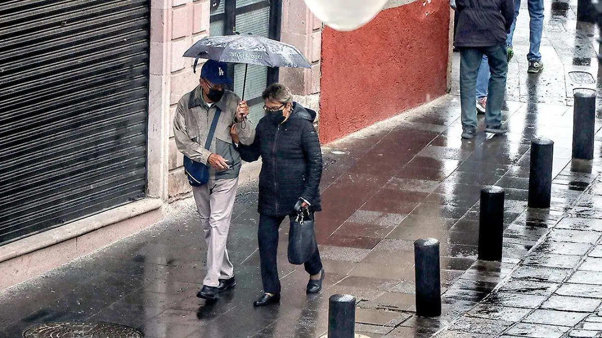 Personas se cubren de la lluvia en el centro de Zacatecas