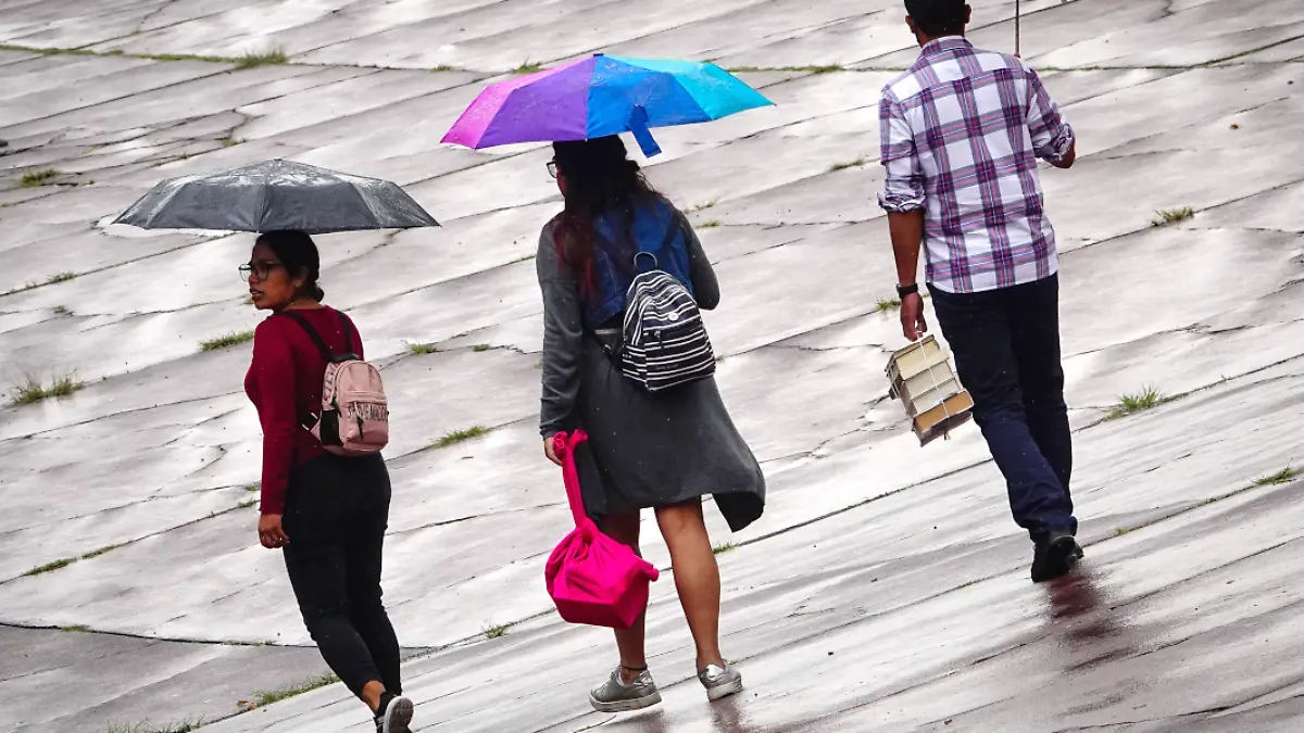 Personas se protegen de la lluvia