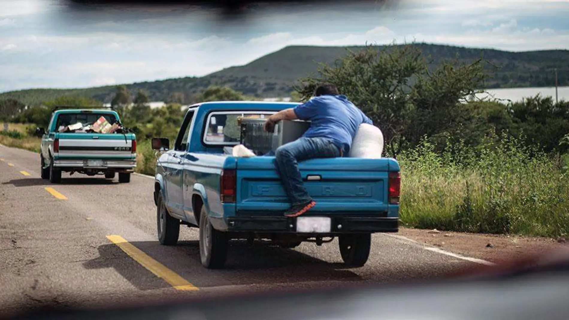 Hombre-subiendo-a-la-caja-de-una-camioneta-en-movimiento