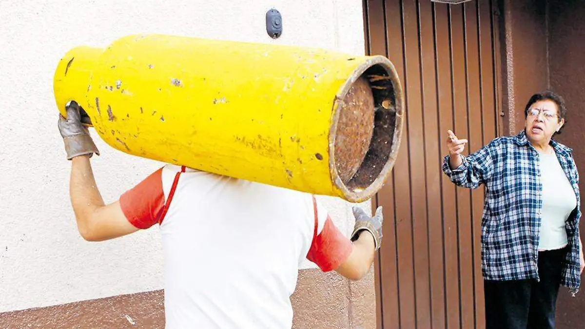 Hombre lleva cilindro de gas a una casa