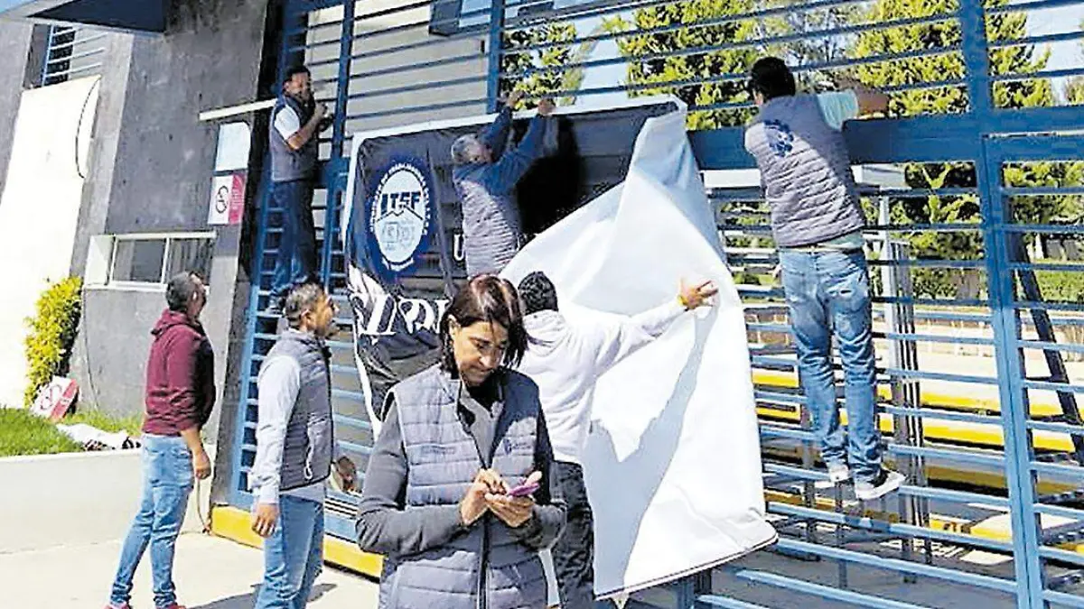 Personal sindicalizado quitando las banderas rojinegras del edifico del ITSF