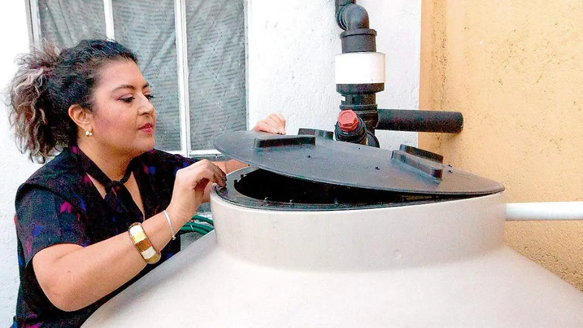 Mujer revisa tanque de agua potable